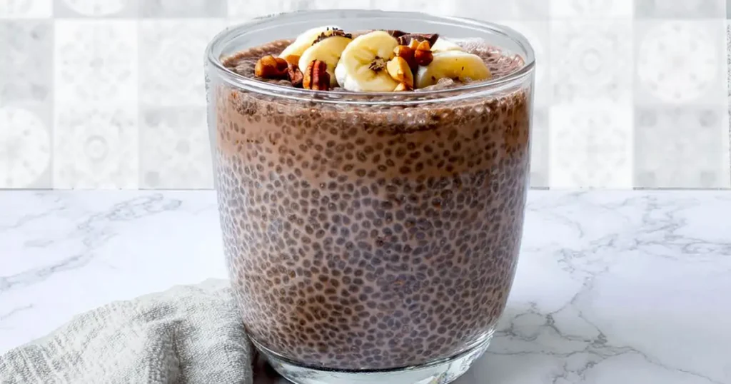 Coffee chia pudding with banana, nuts, and chocolate in a glass jar