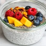 Healthy kefir chia pudding in a jar topped with fresh berries and nuts