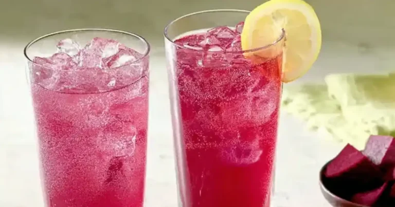 A glass of bright pink beet lemonade, easily made at home using a blender.