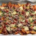 Charcuterie nachos with beef salami, bresaola, melted brie and fig jam on kettle-cooked chips